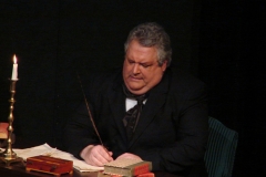 Ebenezer Scrooge in his office